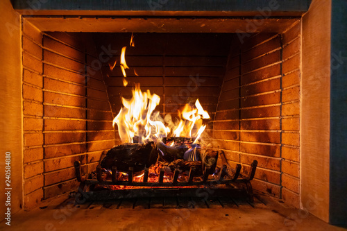 Christmas time. Wood burning in a cozy fireplace at home Fototapeta