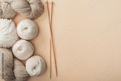 flat lay with yarn and knitting needles on beige backdrop