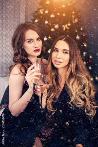 Christmas portrait of two girlfriends with champagne