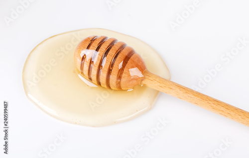 Honey and honey dipper on white background