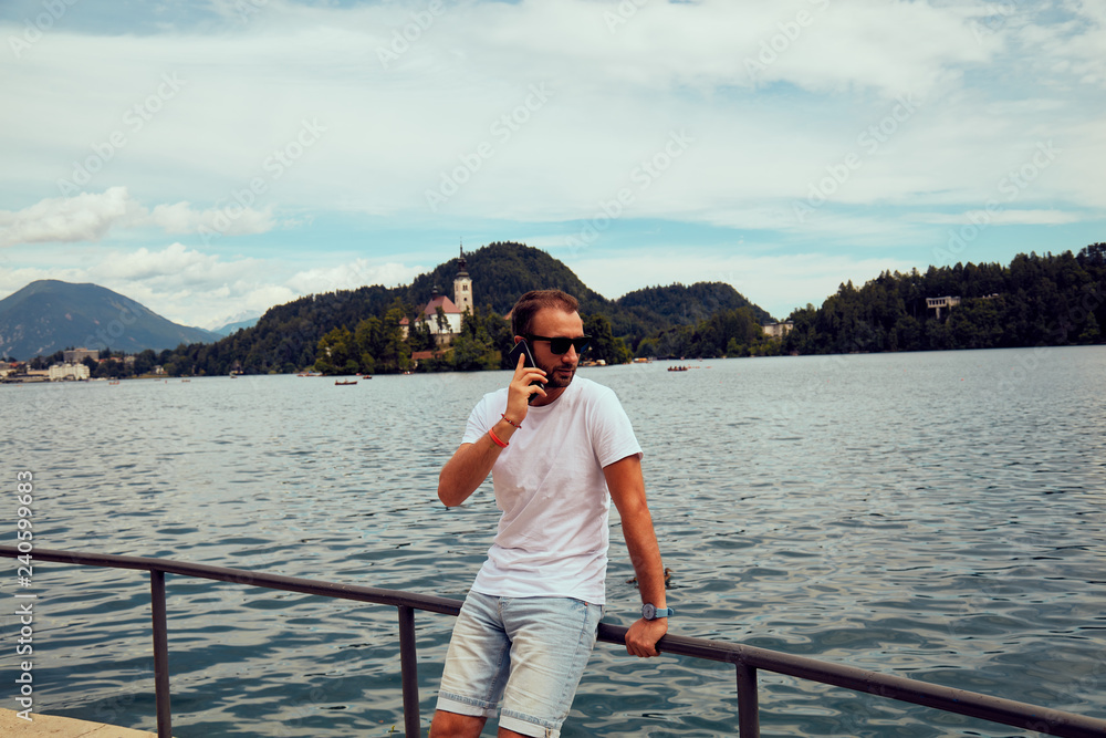 Modern guy using cellphone in the European city.