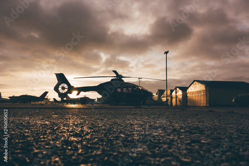 Helicopter on landing place during sunset
