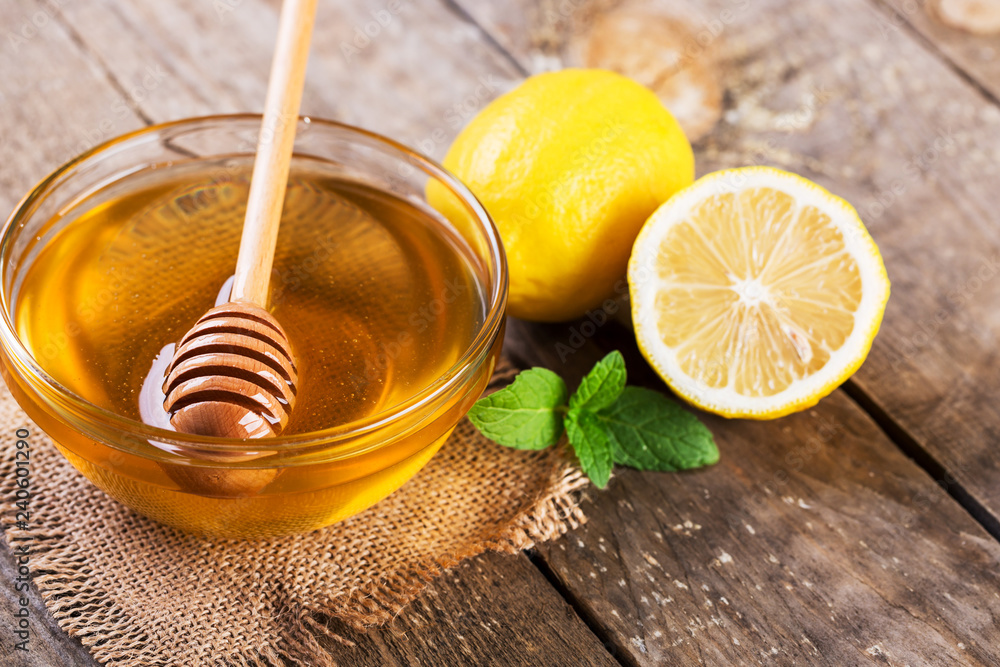 Honey with lemon and mint on wooden table Honey with lemon and mint on wooden table