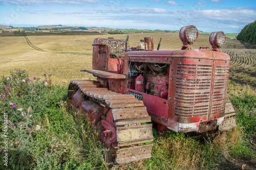 Foto Old trusty tractor sits abandoned at the top of a hill overlooking the fields be
