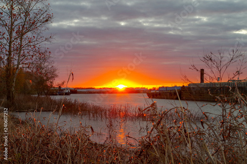 Louisiana sun peeking over the horizon bringing light to the routines of Mississippi river commerce. 