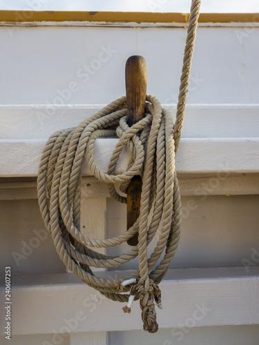 Nagel and coil of rope on the white board of the old schooner photo