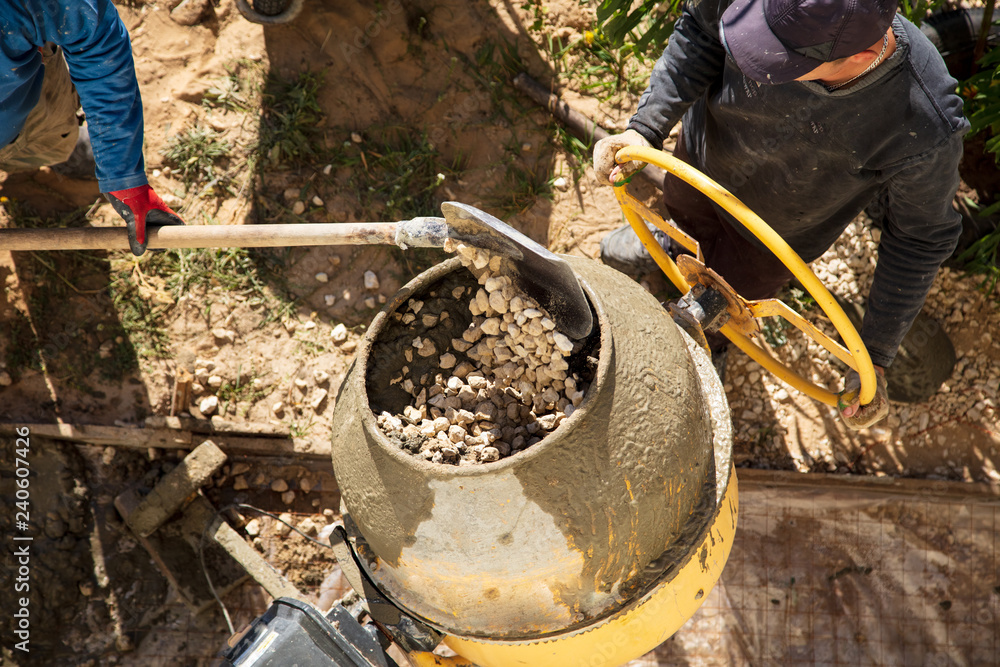 Obraz premium Workers pour concrete solution at a construction site
