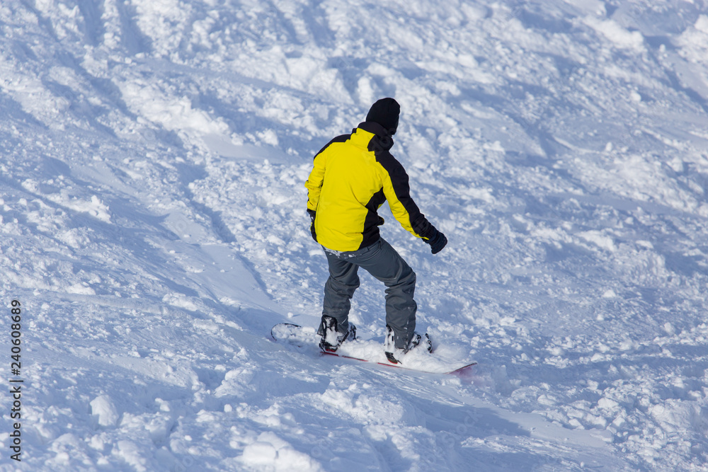 A man snowboarding a mountain in the snow in winter A man snowboarding a mountain in the snow in winter