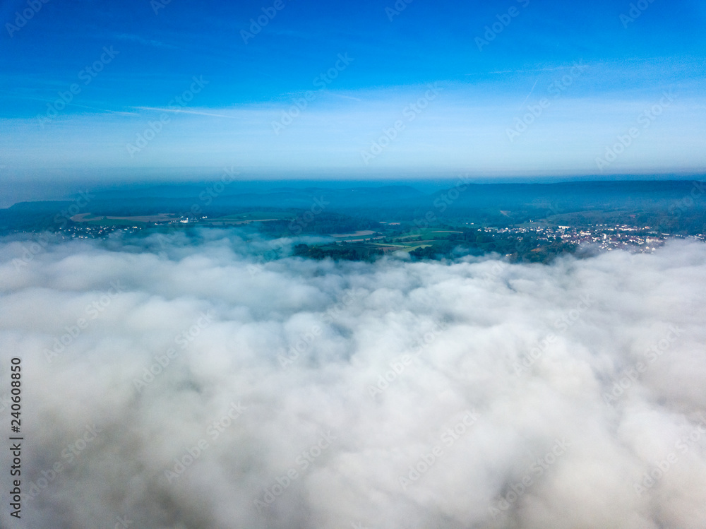Landscape over the morning fog and low clouds and under the blue sky - drone and aerial photography