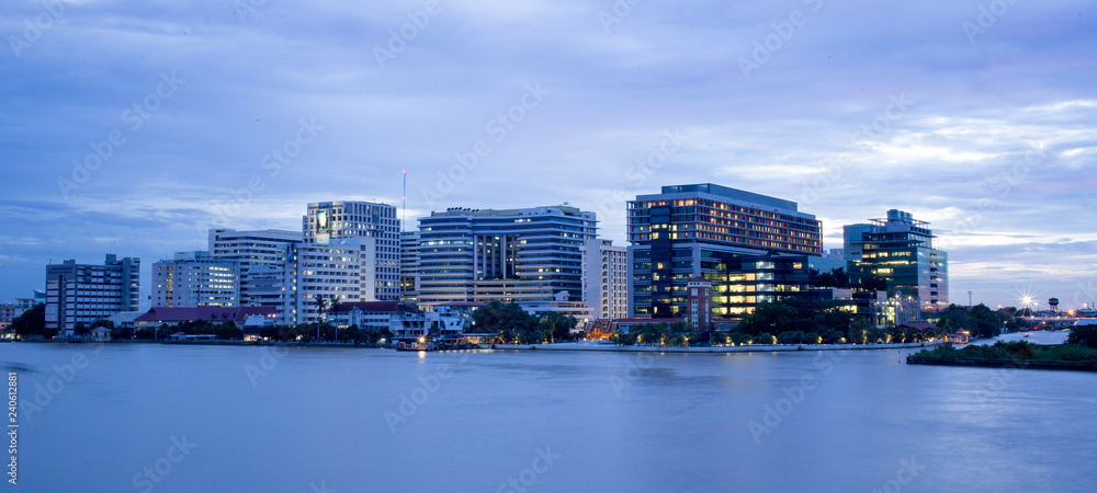 Fototapeta premium Siriraj Hospital A major government hospital in Bangkok, Thailand situated by the Chao Phraya River with twilight light.