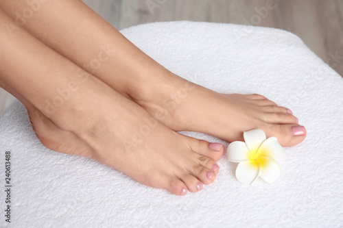 Woman with smooth feet on white towel  closeup. Spa treatment