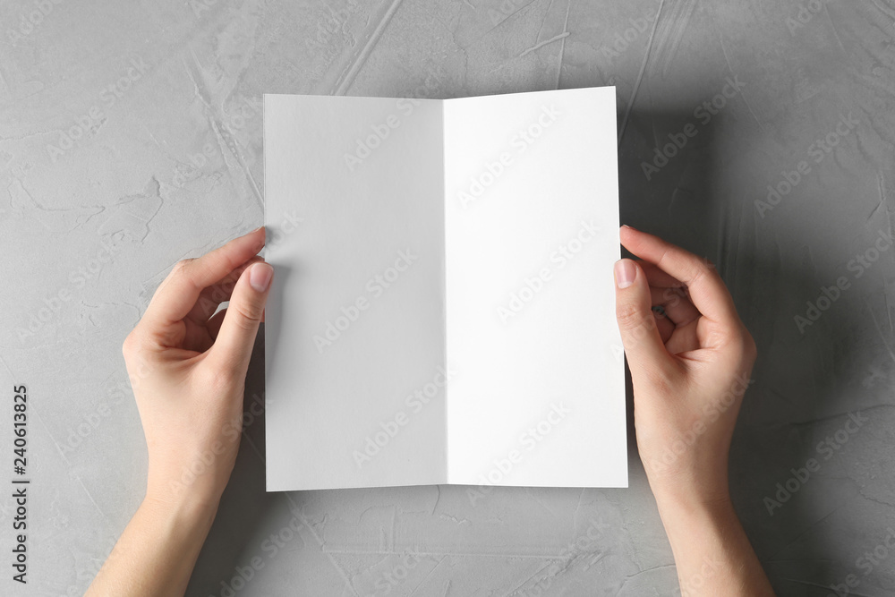 Woman holding blank brochure mock up on light background, top view Woman holding blank brochure mock up on light background, top view