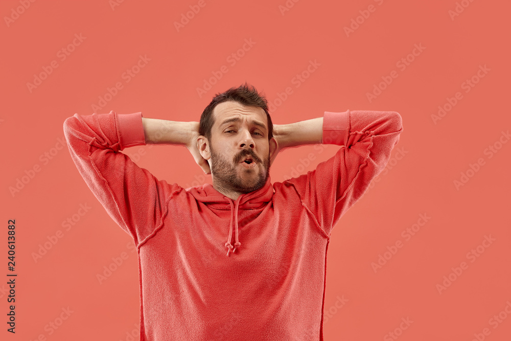 Why is that. Beautiful male half-length portrait isolated on trendy coral studio backgroud. Young emotional surprised, frustrated and bewildered man. Human emotions, facial expression concept. Why is that. Beautiful male half-length portrait isolated on trendy coral studio backgroud. Young emotional surprised, frustrated and bewildered man. Human emotions, facial expression concept.