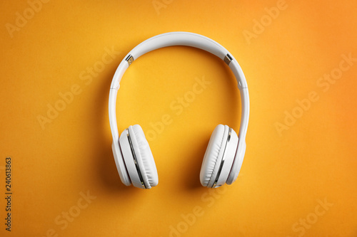 Wireless headphones on color background, top view photo