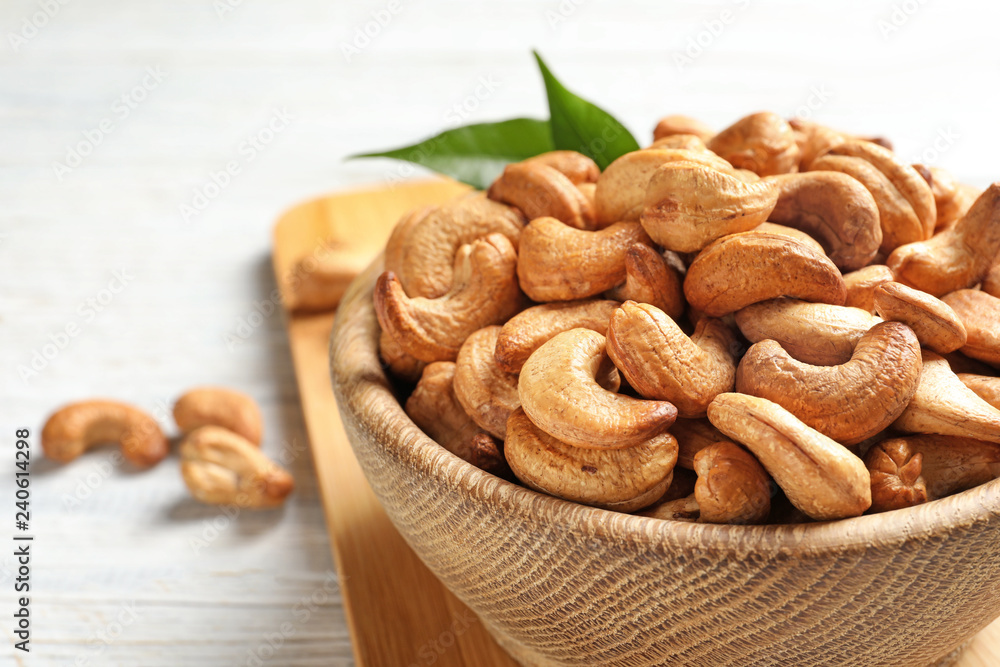 Fototapeta premium Bowl with cashew nuts on table, closeup
