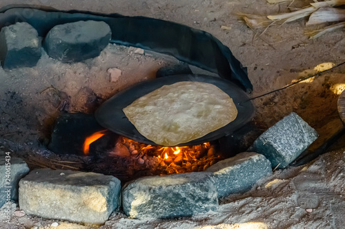 Pita bread cooking on fire in a bedouin dwelling