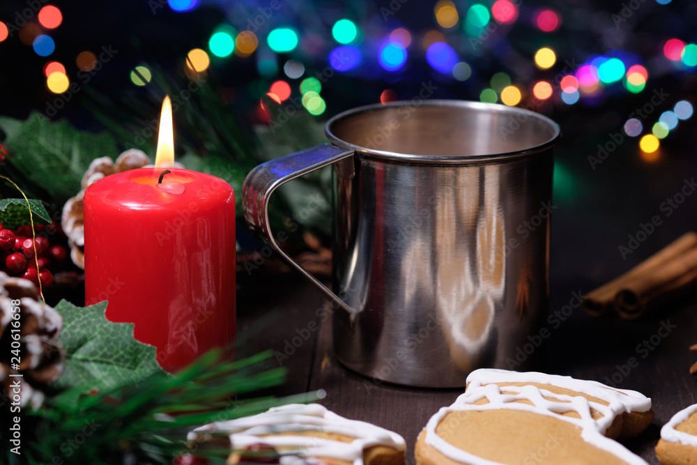 ginger biscuit and coffee with milk in the iron cup on brown wood background with Christmas tree 