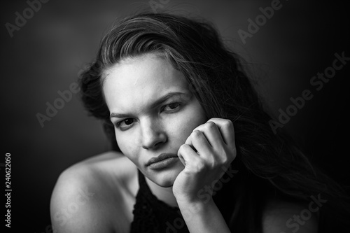 Dramatic black and white portrait of a beautiful girl on a dark background