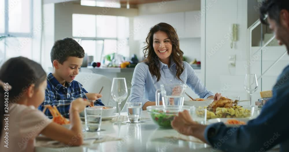 Slow motion of happy family having lunch in dining room. Slow motion of happy family having lunch in dining room.