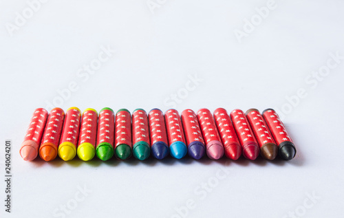 Row of Rainbow wax crayons isolated on white