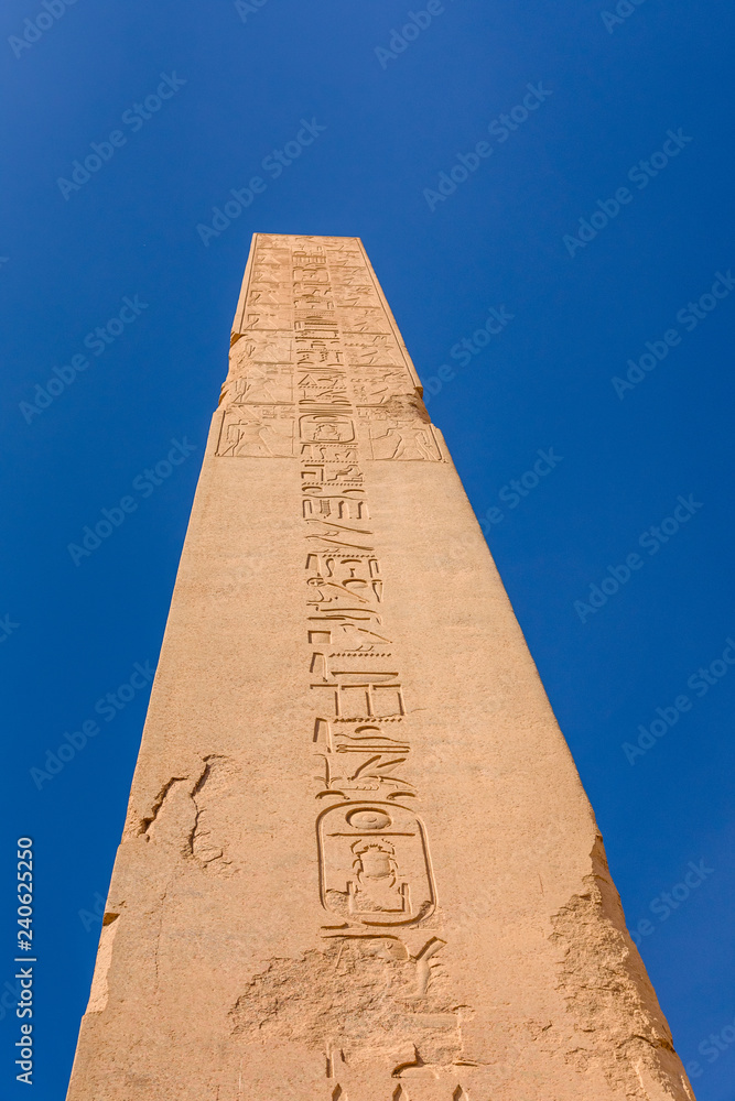 Granite obelisk against blue sky in a Karnak temple. Luxor, Egypt.