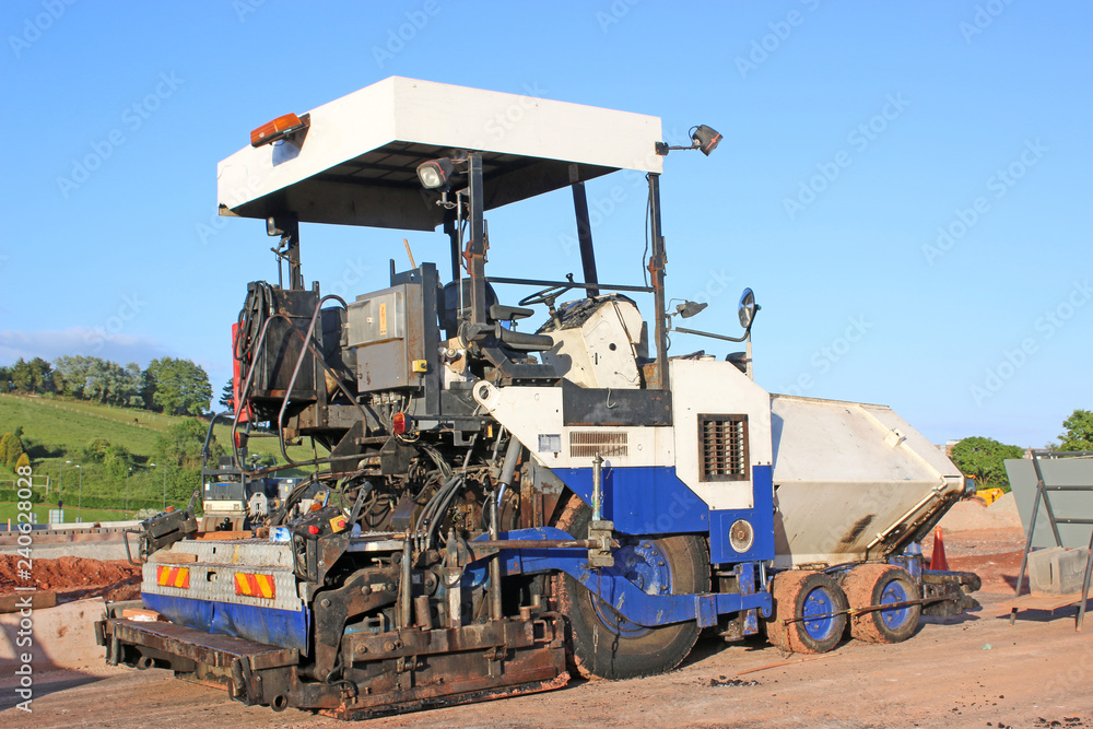 Asphalt paver on a construction site Asphalt paver on a construction site