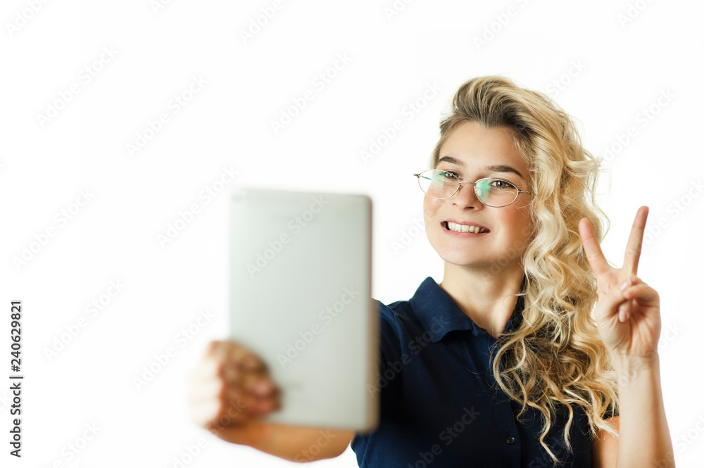 Naklejka premium Happy business woman standing with table computer over background. Wear a blue shirt and glasses. Talking with a gadget