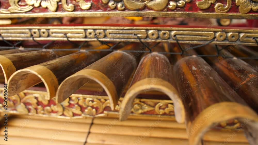 Traditional Balinese Music Instument Gamelan. Asian Musician Man in Traditional Clothes Playing on Bamboo Xylophone at Ceremony in Temple. 4K. Bali, Indonesia.
