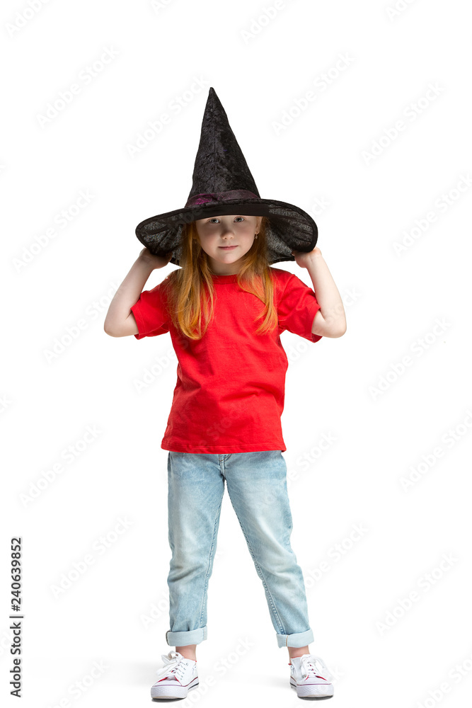 Full length portrait of cute little kid girl in stylish jeans clothes looking at camera and smiling, standing against white studio wall. Kids fashion concept Full length portrait of cute little kid girl in stylish jeans clothes looking at camera and smiling, standing against white studio wall. Kids fashion concept