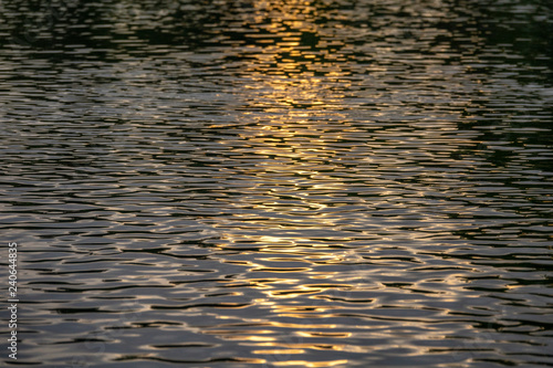 Setting sun reflecting on river water patterns