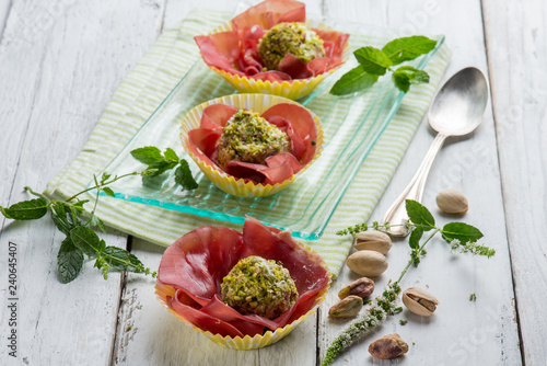 ricotta cheese meatballs with pisctachio nuts over bresaola