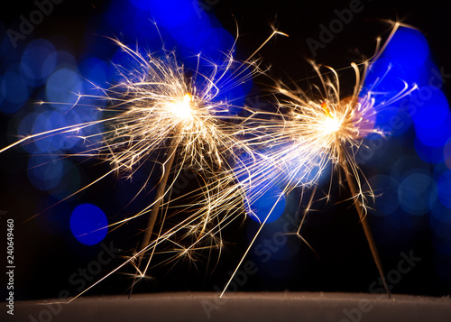 burning sparkler on bokeh background from lights of garland photo