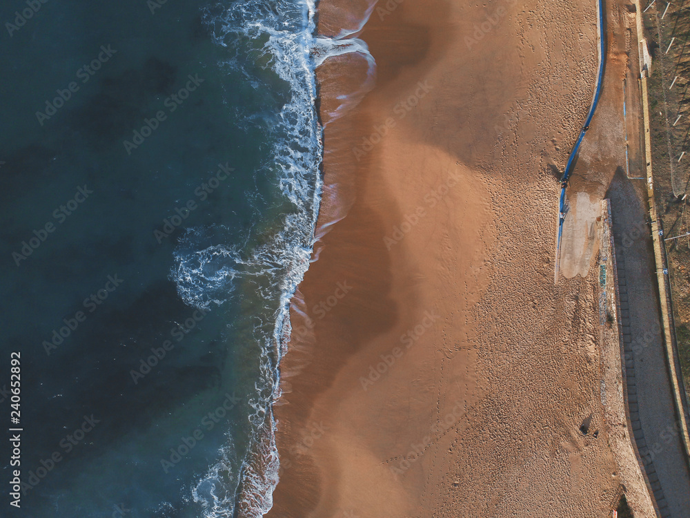 Sand beach aerial, top view of a beautiful sandy beach aerial shot with the blue ocean water