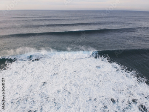 Aerial view from ocean waves in a surf spot at the sunset . Drone Photo.