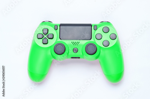 Modern green plastic gamepad (joystick) on gray background. Top view.