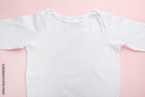 Layout Flat Lay white baby shirt, on a pink background, for the girl.Mock up for design and placement of logos, advertisements