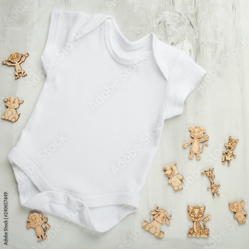Layout Flat Lay white baby bodysuit shirt, on a white background with children's wooden toys. Mock up for design and placement of logos, advertisements © Anton