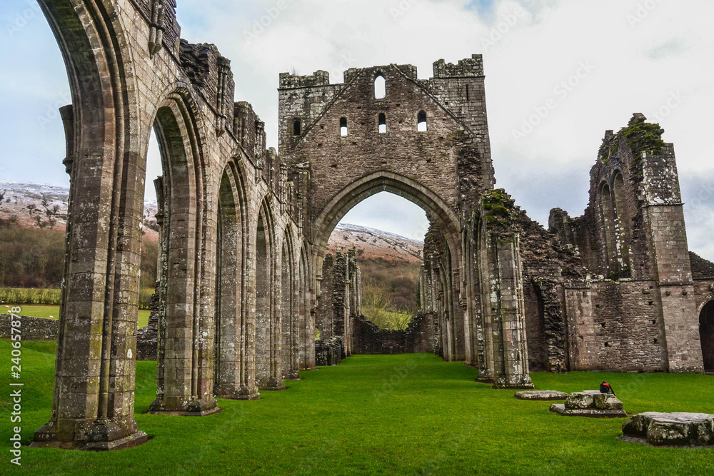 Fototapeta premium Landmarks of Wales travel concept. View of ancient ruins of the castle/church in Brecon Beacons National Park, United Kingdom. Popular tourist attraction (Llanthony Priory,Hay-on-Wye, Black Mountains)