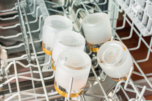 Small glasses of vodka lie in the middle compartment of the dishwasher