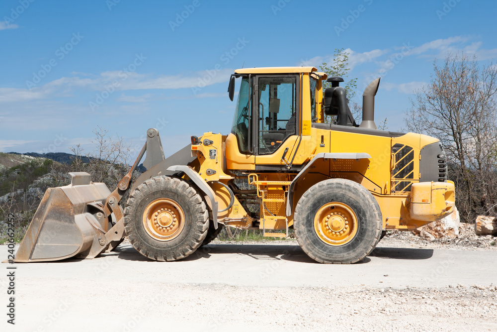 Heavy yellow wheel loader excavator, close-up.