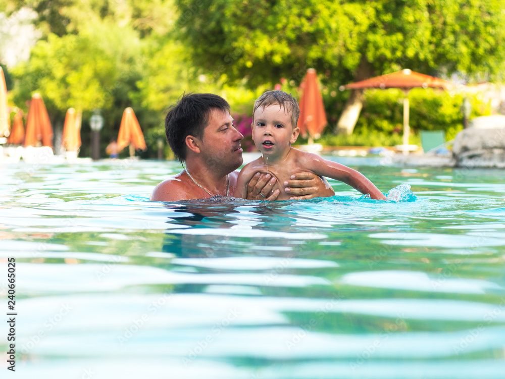 Father and child swimming in the pool Father and child swimming in the pool