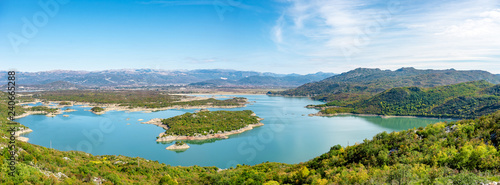 Panorama of lake with mountain with island, salt lake in Montenegro in calm waters of lake