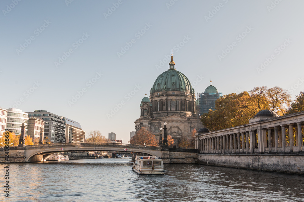 Berlin Cathedral with the Frederick's Bridge at blue sky. Arcade of the National Gallery on the river bank Spree with buildings of capital Berlin at the autumn vibes
