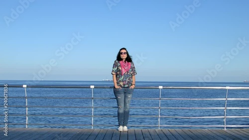 4K General view of a attractive woman in red scarf standing on the pier.