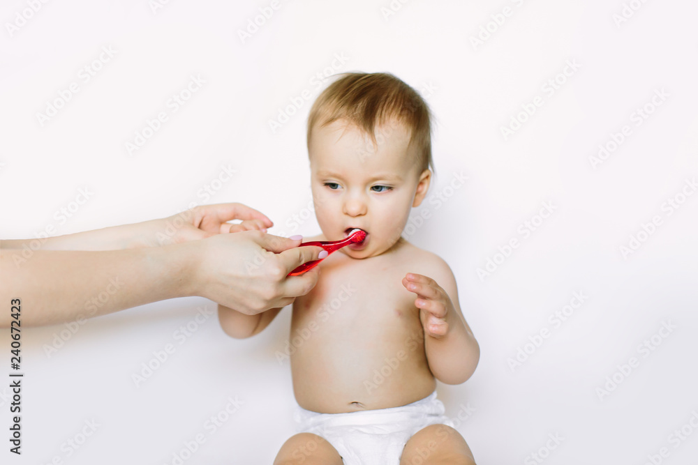Little baby girl learning to brush teeth with mother's help, isolated on white background Little baby girl learning to brush teeth with mother's help, isolated on white background