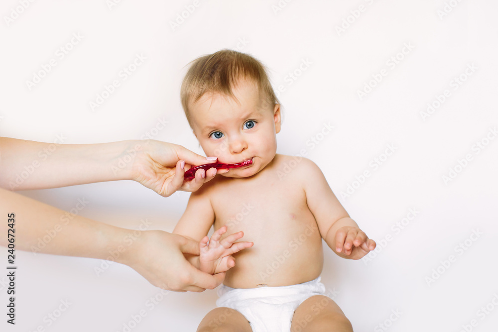 Little baby girl learning to brush teeth with mother's help, isolated on white background Little baby girl learning to brush teeth with mother's help, isolated on white background