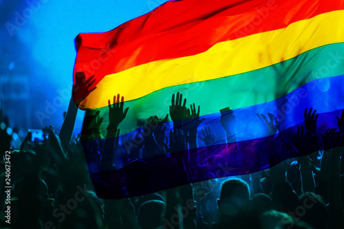 silhouette of a parade of gays and lesbians with a rainbow flag - symbol of love and tolerance photo