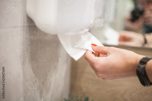 Wallpaper Mural Paper towel dispenser. Hand of woman takes paper towel in bathroom Torontodigital.ca