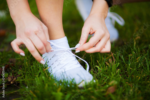 Healthy lifestyle. Beautiful woman runner tying shoelaces