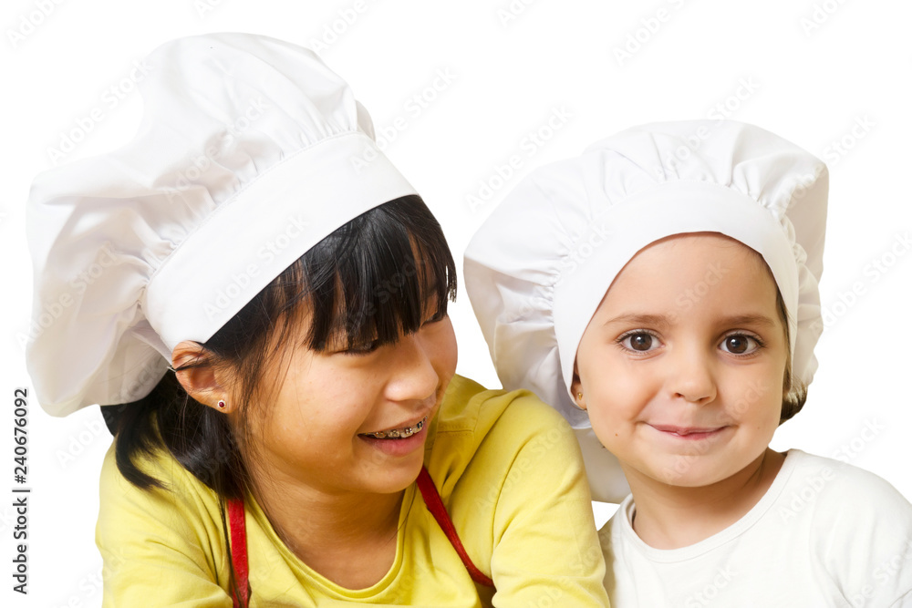 funny happy china girl and caucasian girl with chef hats in kitchen funny happy china girl and caucasian girl with chef hats in kitchen